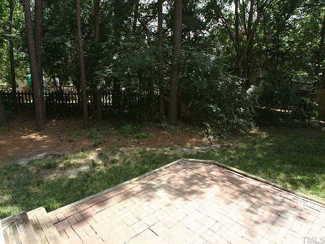 5405 Islehurst Court Raleigh, NC 27613 - Photo 8 of 12 a backyard of a house with lots of green space and fountain