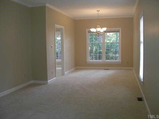 5405 Islehurst Court Raleigh, NC 27613 - Photo 10 of 12 an empty room with windows and chandelier