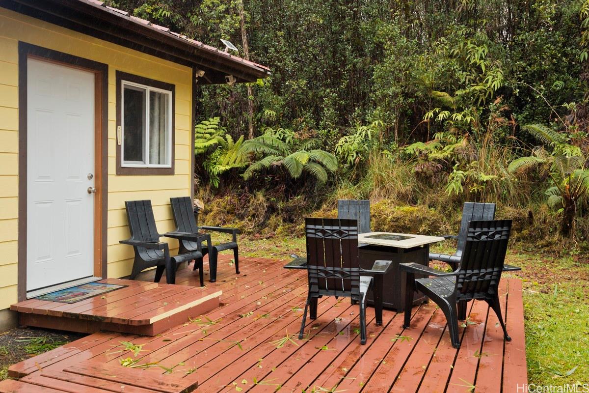 18-2274 Laulea Road Volcano, HI 96785 - Photo 14 of 15 Outdoor deck area with seating, creating a usable space for enjoying the surrounding tropical environment