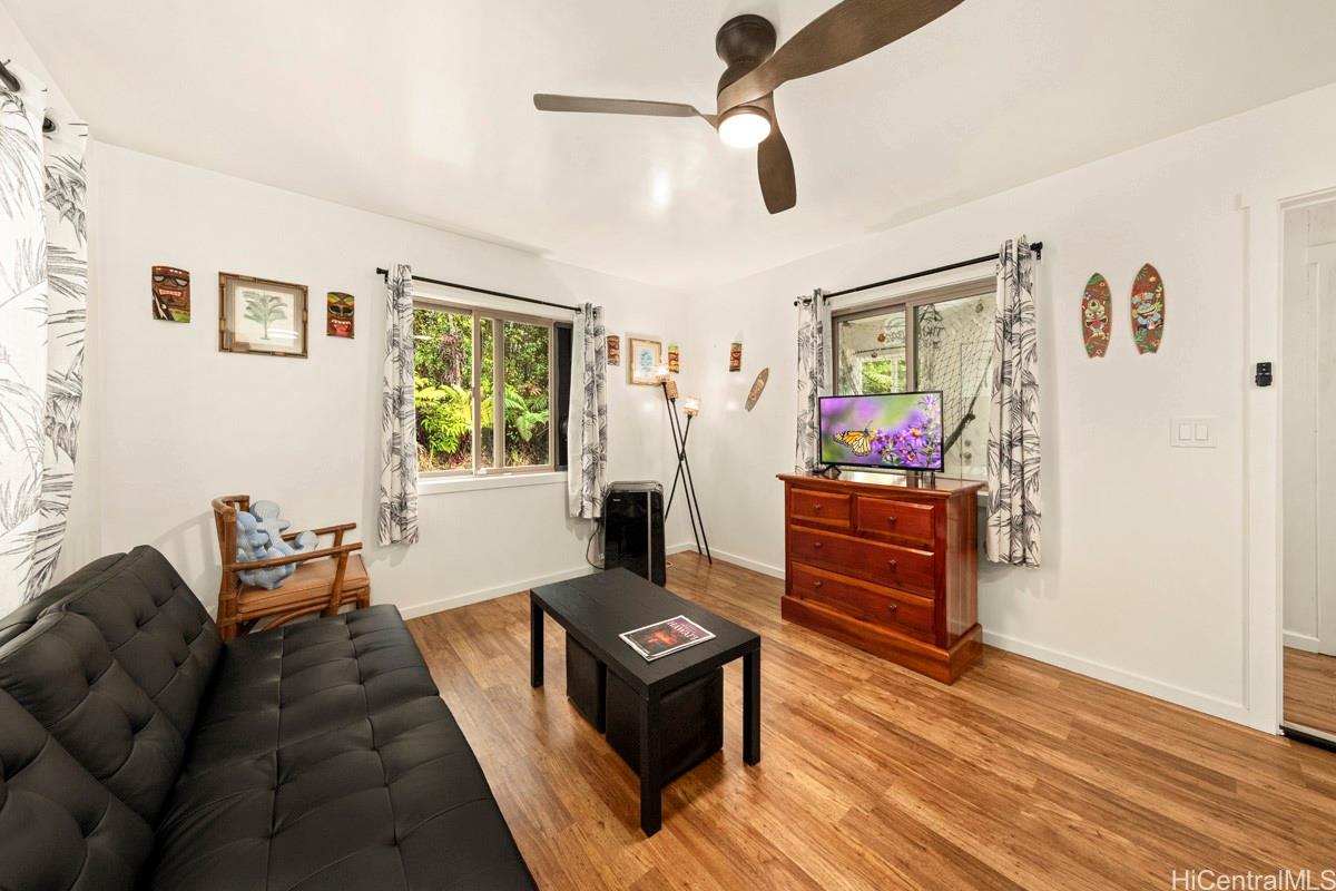 18-2274 Laulea Road Volcano, HI 96785 - Photo 2 of 15 Light-filled living space with large windows and open layout, creating a comfortable interior within this Big Island forest home