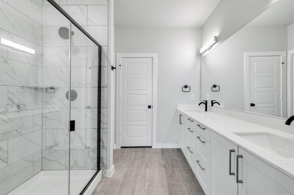 7050-7052 Guilford Road Midlothian, TX 76065 - Photo 21 of 36 a spacious bathroom with a double vanity sink and mirror