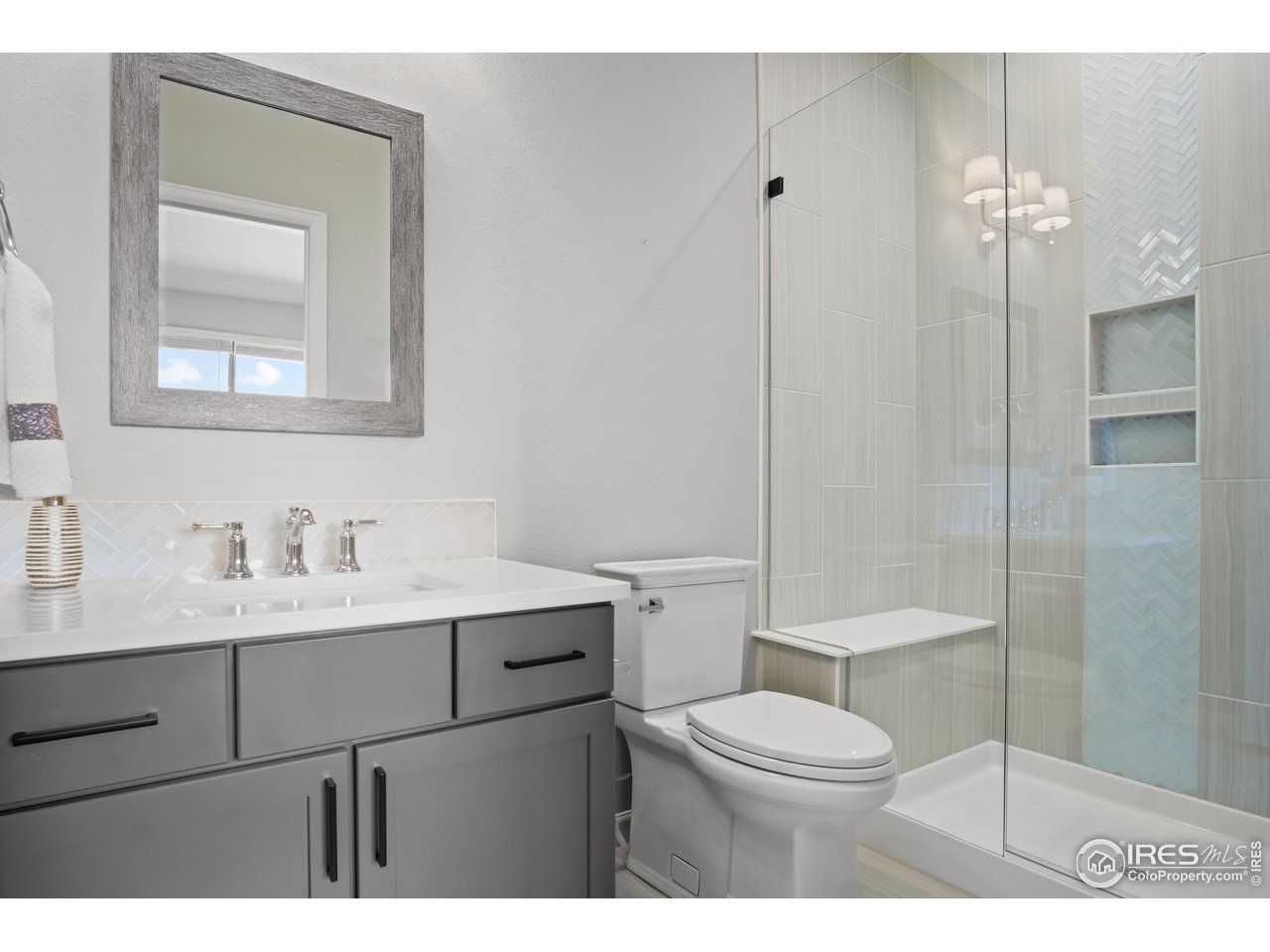 822 Canoe Birch Drive Windsor, CO 80550 - Photo 11 of 14 a bathroom with a toilet a sink a glass door a shower a mirror and vanity