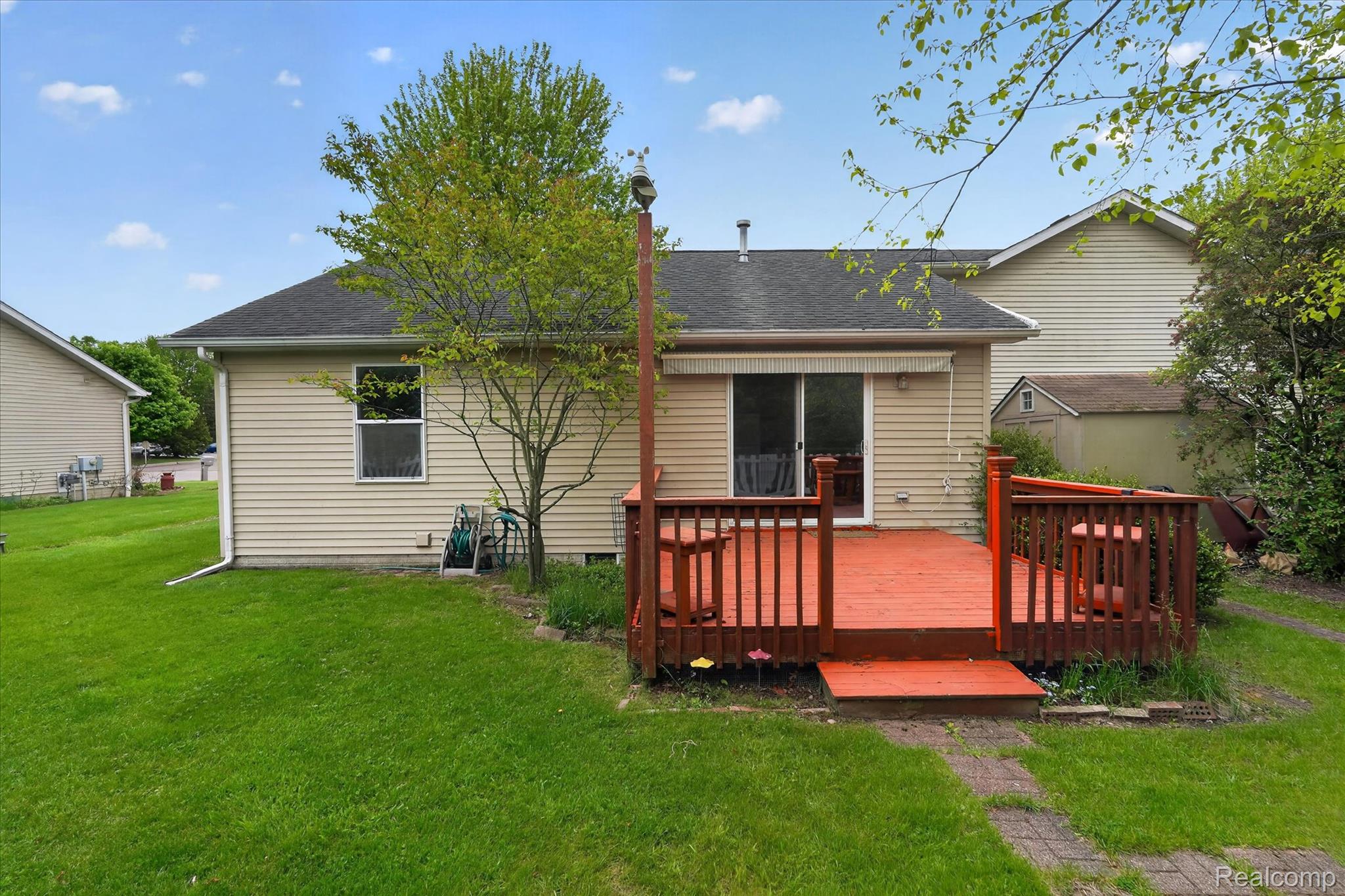 1607 Cedarwood Drive Flushing, MI 48433 - Photo 25 of 27 Back of property featuring a yard, a wooden deck, and roof with shingles