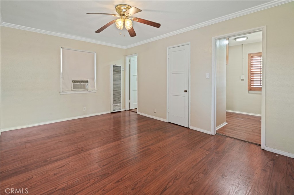 6786 Delta Avenue Long Beach, CA 90805 - Photo 13 of 16 an empty room with wooden floor chandelier fan and windows