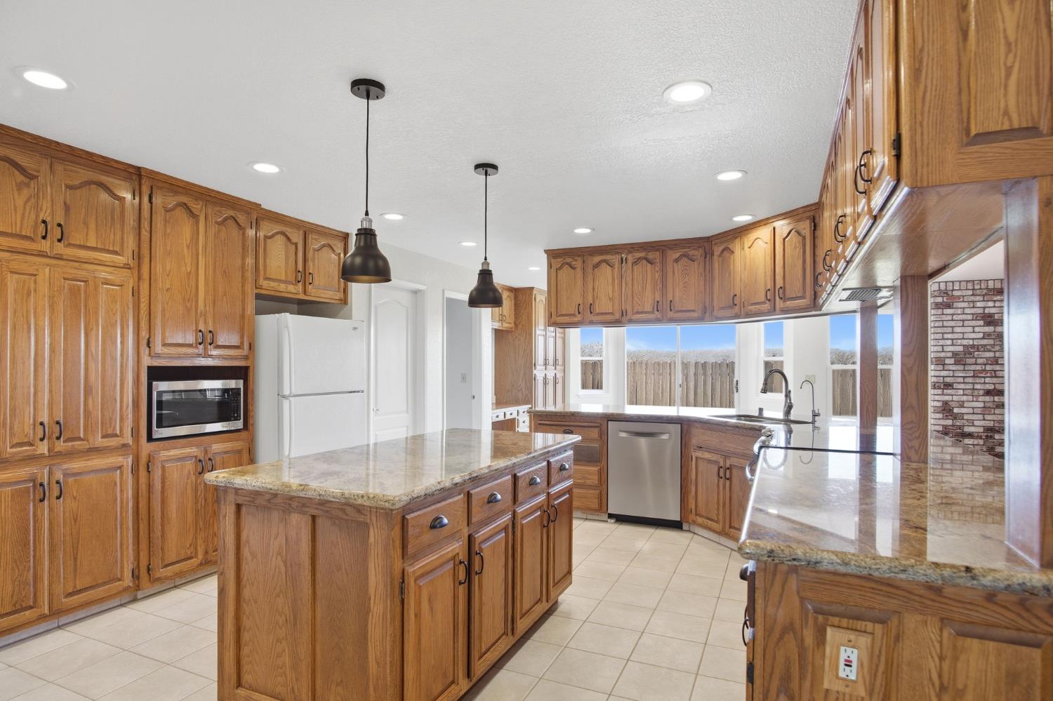 16166 Lawrence Road Escalon, CA 95320 - Photo 12 of 56 a kitchen with stainless steel appliances granite countertop a stove a sink and a refrigerator
