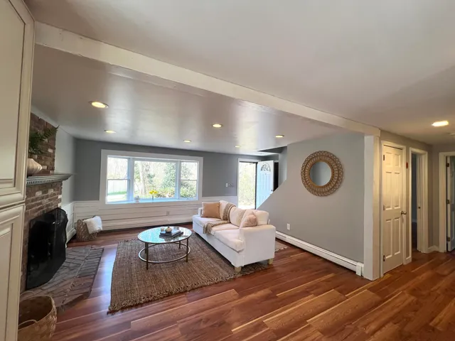 a living room with furniture a fireplace and a window
