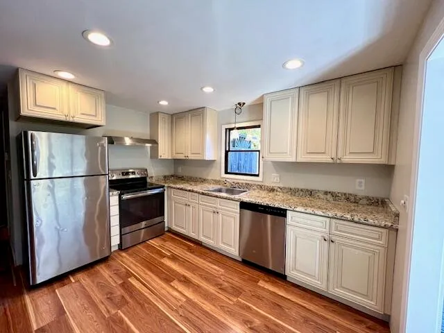 a kitchen with granite countertop stainless steel appliances and wooden cabinets
