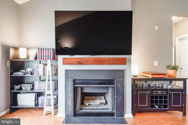 a living room with stainless steel appliances furniture a fireplace and a fireplace