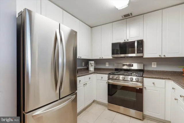 a kitchen with stainless steel appliances a refrigerator stove and microwave