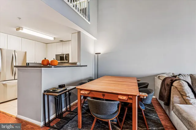 a kitchen with stainless steel appliances a table chairs and a refrigerator