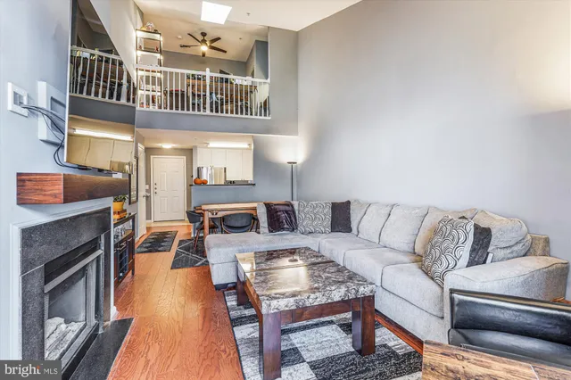 a living room with furniture a fireplace and a kitchen view