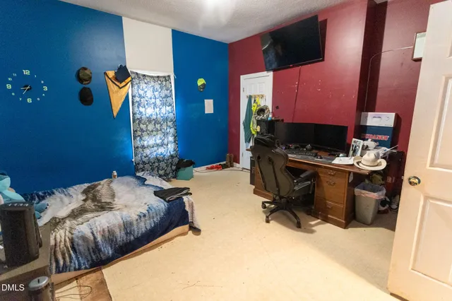 a bedroom with a bed and a flat screen tv