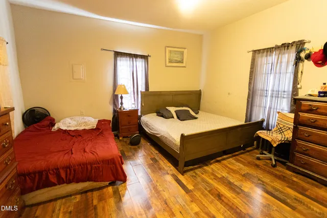 a bedroom with two beds and painting on the wall