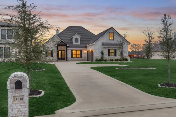 a front view of a house with yard and green space
