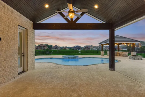 an empty room with wooden floor fireplace and staircase