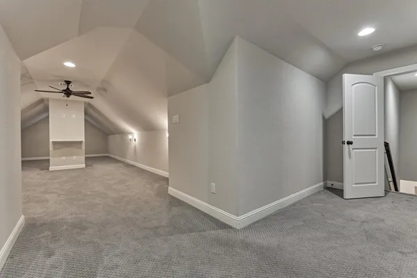 en empty room with windows and fan