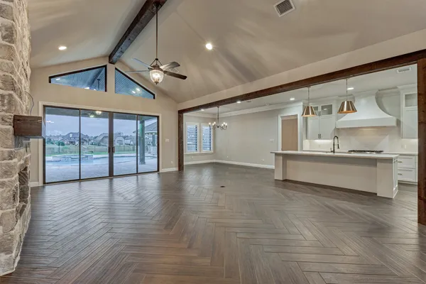 a living room with furniture kitchen view and a large window