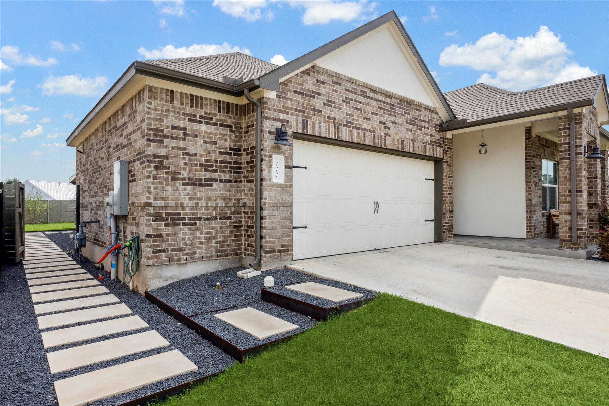 700 Legends Lane Georgetown, TX 78628 - Photo 4 of 31 View of front facade with concrete driveway, a garage, brick siding, and stucco siding