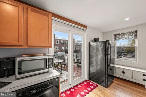 a kitchen with granite countertop a refrigerator and a stove top oven