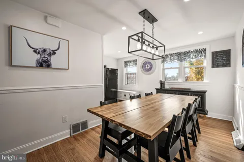 a view of a dining room and livingroom with furniture wooden floor a chandelier