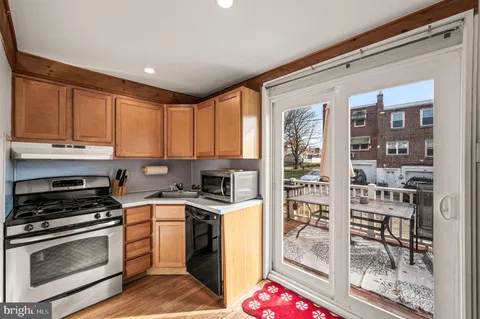 a kitchen with granite countertop a stove a sink and a refrigerator