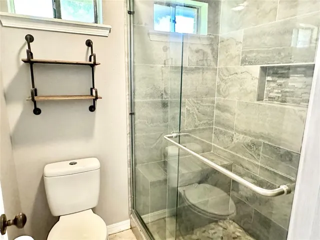 a bathroom with a toilet and a shower