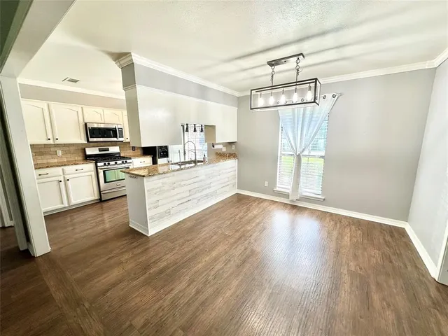 a kitchen with stainless steel appliances a stove top oven and cabinets