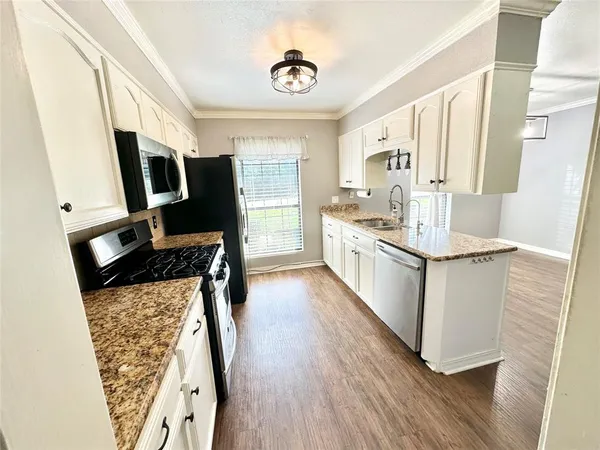 a kitchen with stainless steel appliances a stove a sink and a refrigerator