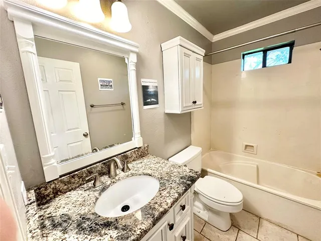 a bathroom with a granite countertop sink mirror vanity and toilet