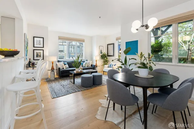 a living room with furniture a large window and a dining table