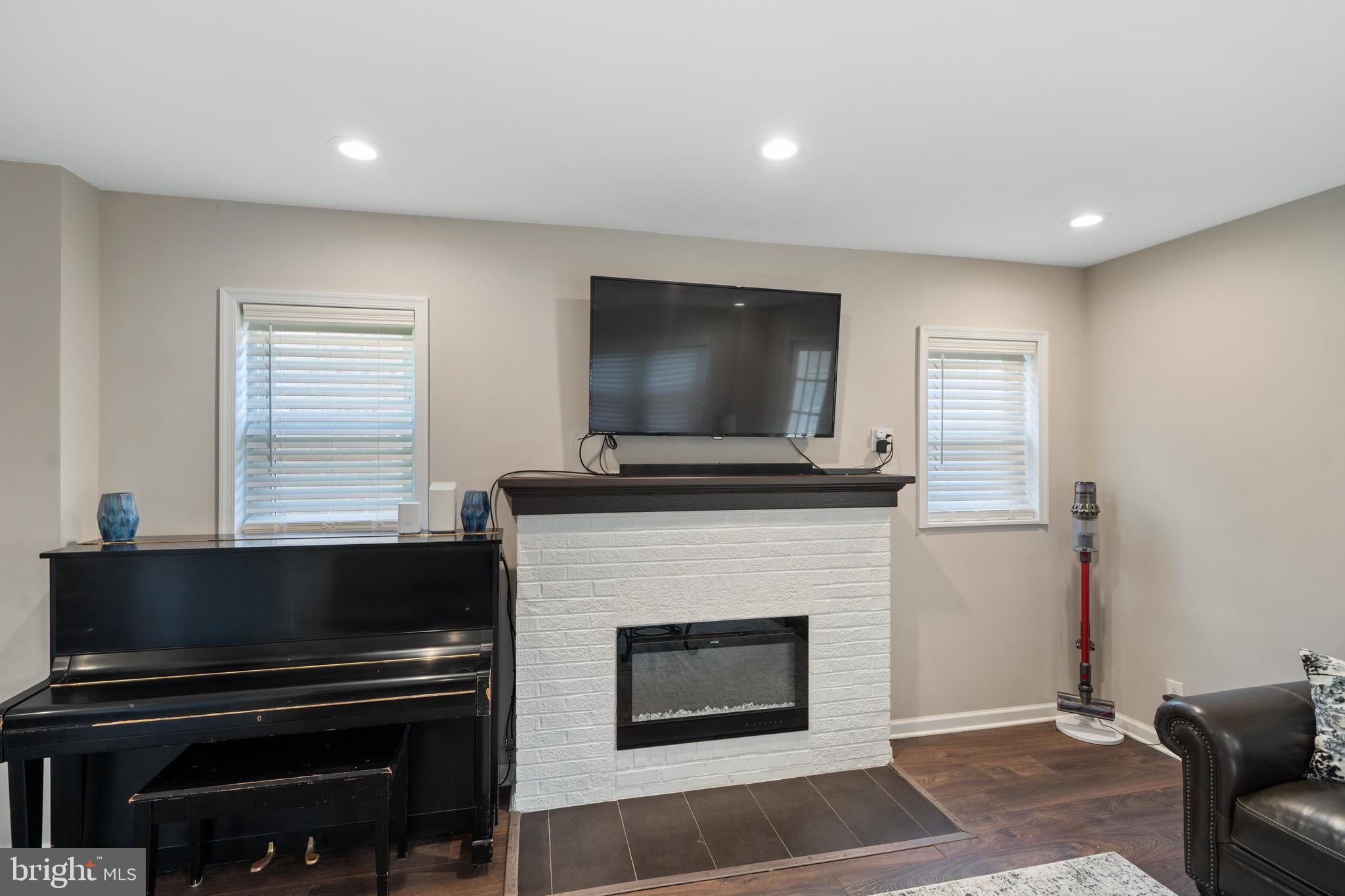 261 East Avon Road Brookhaven, PA 19015 - Photo 10 of 34 a living room with a fireplace and a flat screen tv