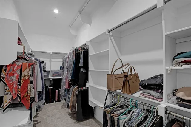 a view of walk in closet with clothes and shoes
