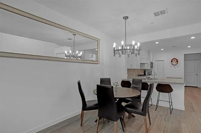 a view of a dining room with furniture a chandelier and wooden floor