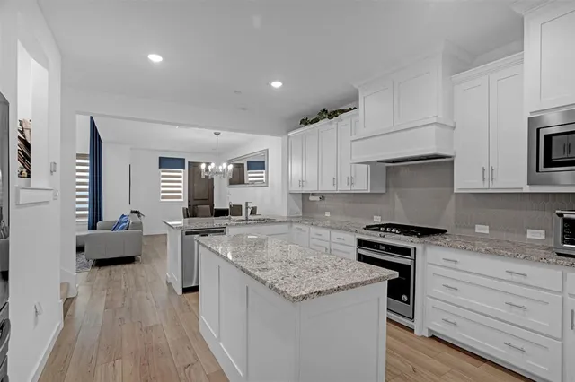 a kitchen with granite countertop kitchen island wooden cabinets and stainless steel appliances