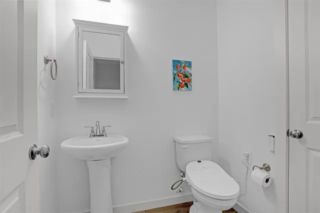 a bathroom with a toilet sink and mirror