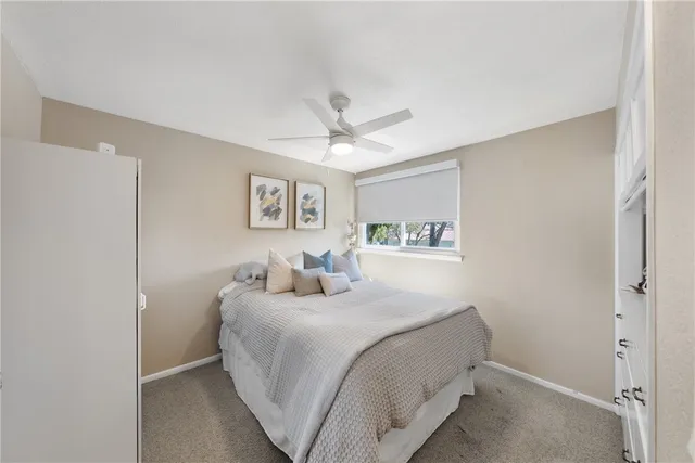 a bedroom with a bed and a ceiling fan