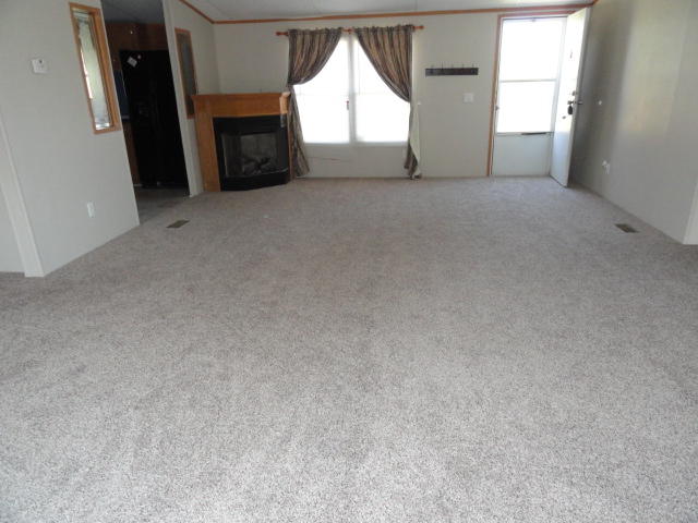 1512 McCauley Road Baker, FL 32531 - Photo 3 of 18 an empty room with a fireplace and windows