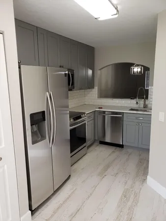 a kitchen with stainless steel appliances a refrigerator sink and microwave