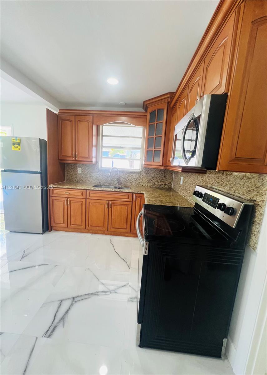 15530 Southwest 295th Terrace Homestead, FL 33033 - Photo 6 of 14 a kitchen with stainless steel appliances granite countertop a stove a sink and a microwave