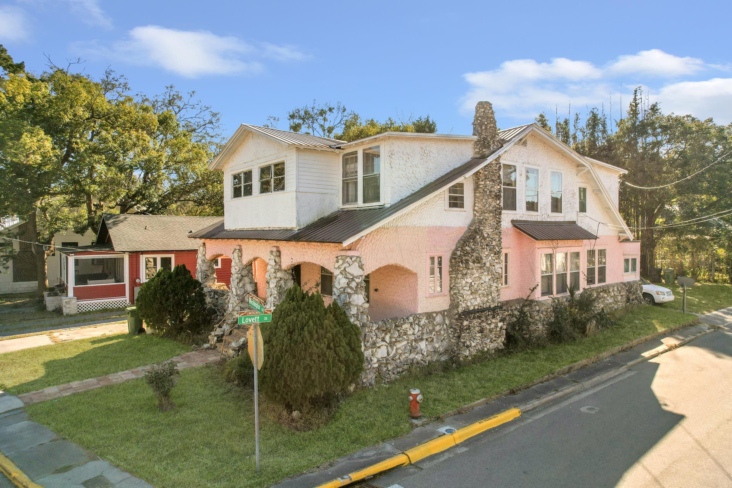 134 Washington Street St. Augustine, FL 32084 - Photo 2 of 41 View of front facade with a standing seam roof, a front lawn, and stone siding