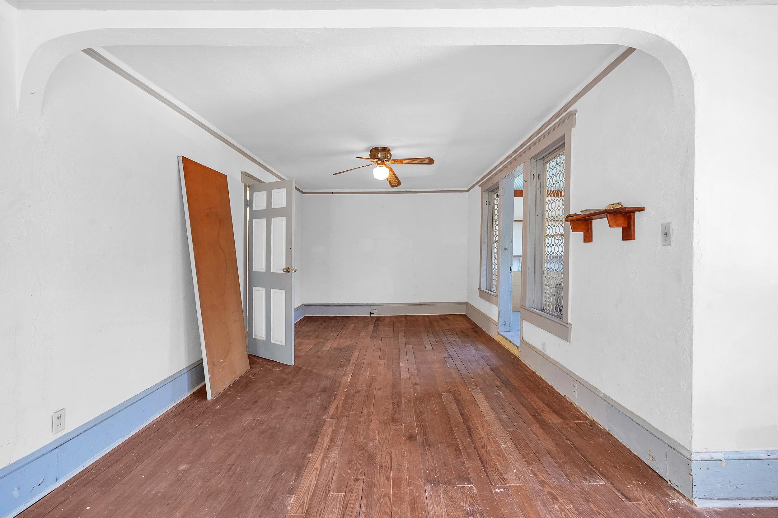 134 Washington Street St. Augustine, FL 32084 - Photo 22 of 41 Empty room with arched walkways, dark wood-style floors, ceiling fan, and ornamental molding