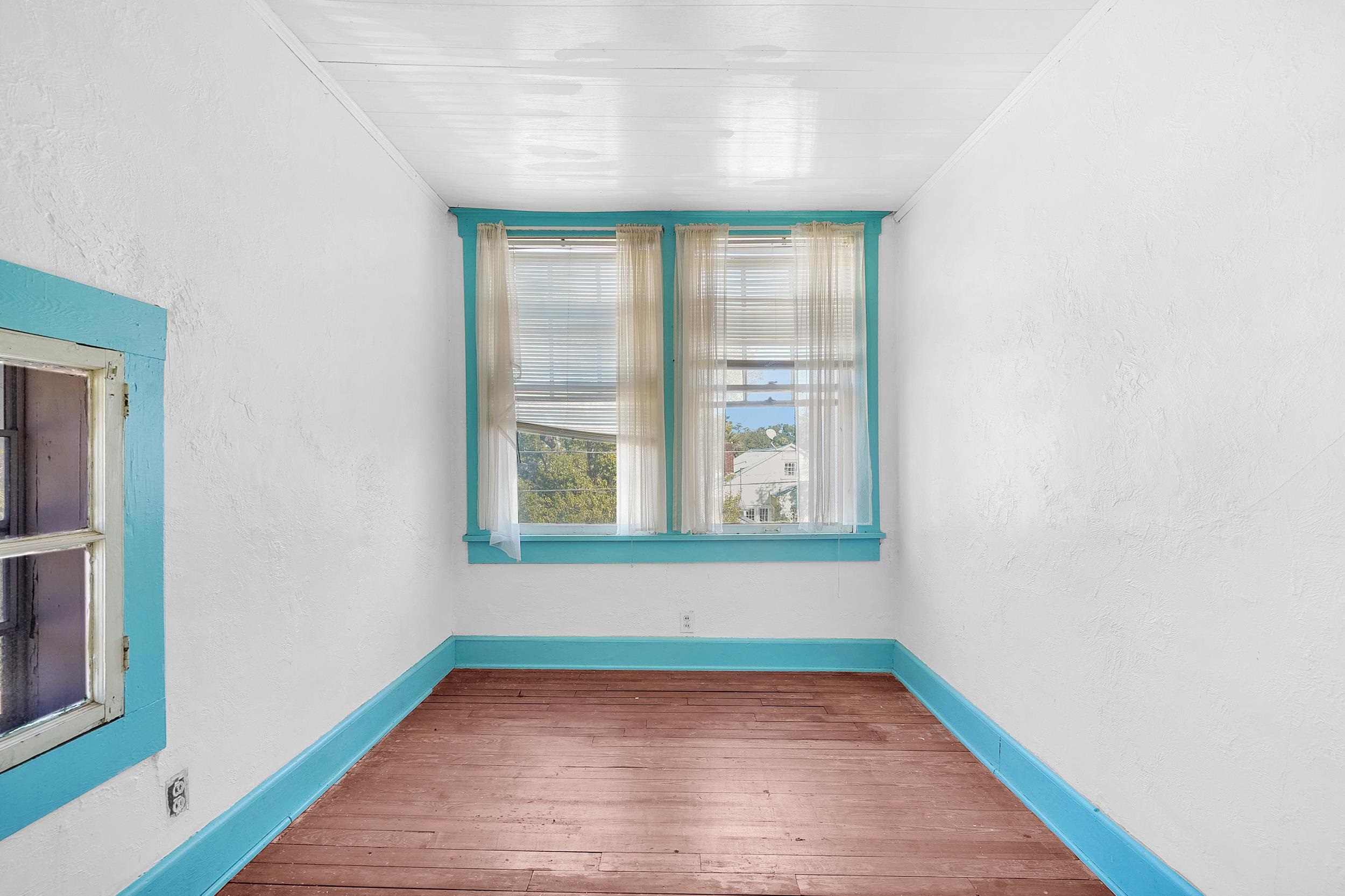 134 Washington Street St. Augustine, FL 32084 - Photo 27 of 41 a view of an empty room with wooden floor and a window