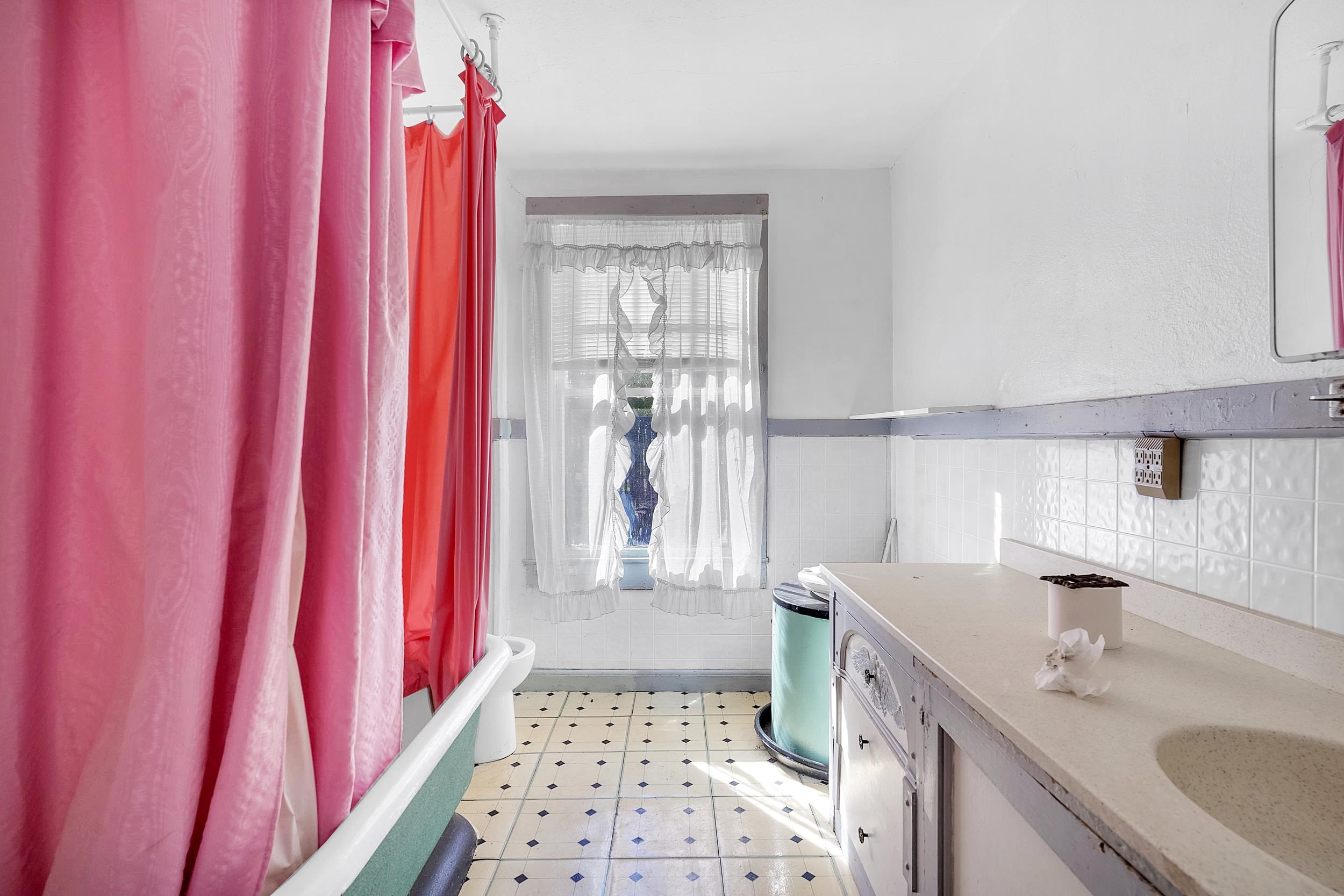 134 Washington Street St. Augustine, FL 32084 - Photo 34 of 41 Bathroom featuring light flooring, vanity, shower / tub combo, a wainscoted wall, and tile walls