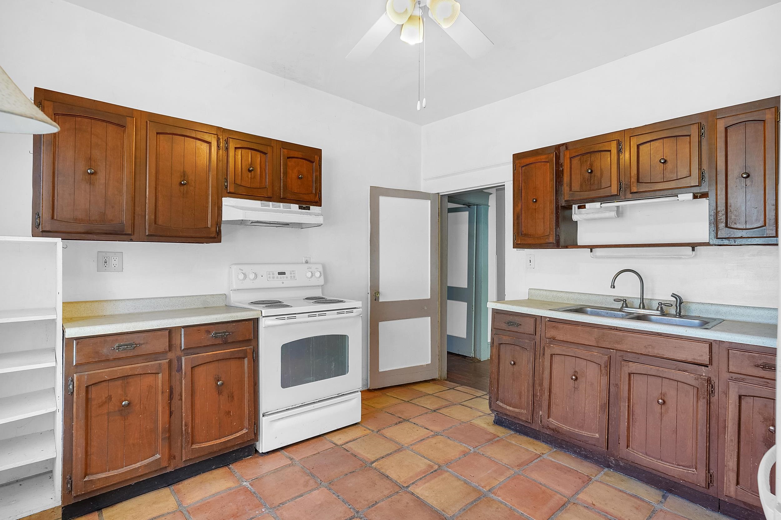 134 Washington Street St. Augustine, FL 32084 - Photo 6 of 41 Kitchen with white appliances, light countertops, ceiling fan, and wood finish cabinetry