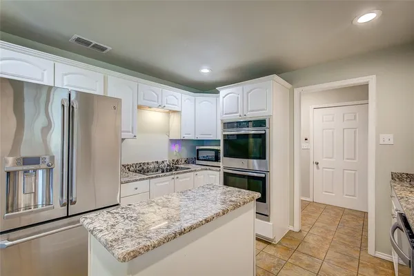 a kitchen with stainless steel appliances granite countertop a refrigerator oven stove a sink and a granite counter tops