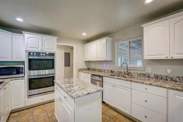 a kitchen with stainless steel appliances granite countertop a stove sink and cabinets