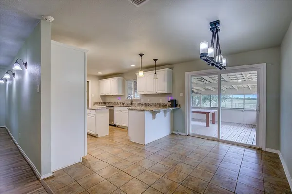 a kitchen with kitchen island granite countertop a refrigerator and a stove top oven