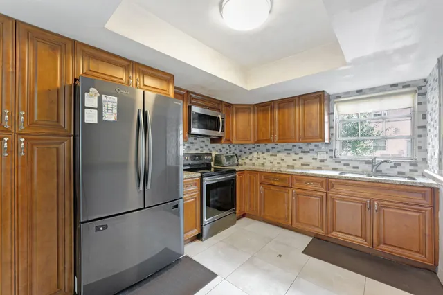 a kitchen with stainless steel appliances granite countertop a refrigerator sink and cabinets