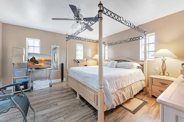 a bedroom with a bed a chandelier and next to a window