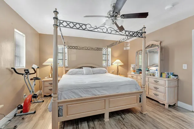 a bedroom with a bed a chandelier and dresser